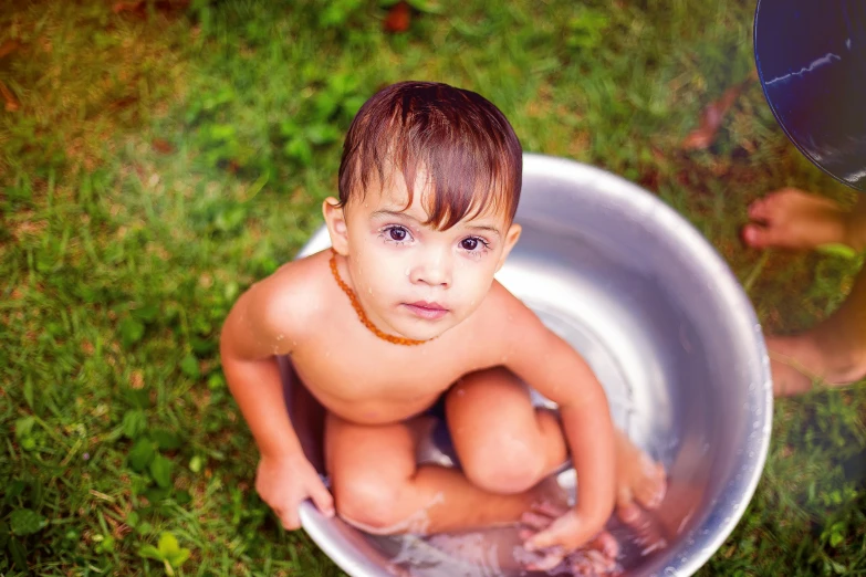 a little boy that is sitting in a bowl, by Julia Pishtar, pexels, wet shiny skin, thumbnail, 268435456k film, clean hair