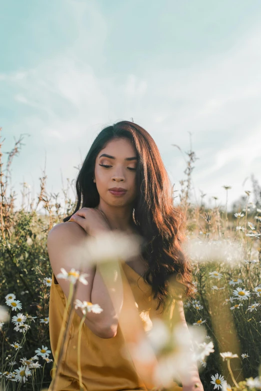 a woman sitting in a field of flowers, trending on pexels, wavy hair yellow theme, asian descent, low quality photo, skies