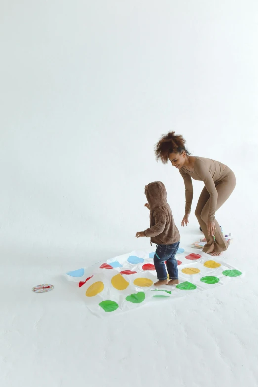 a woman playing with a child on a polka dot mat, by Ottó Baditz, interactive art, fullbodysuit, painted with colour on white, promotional image, kids toy