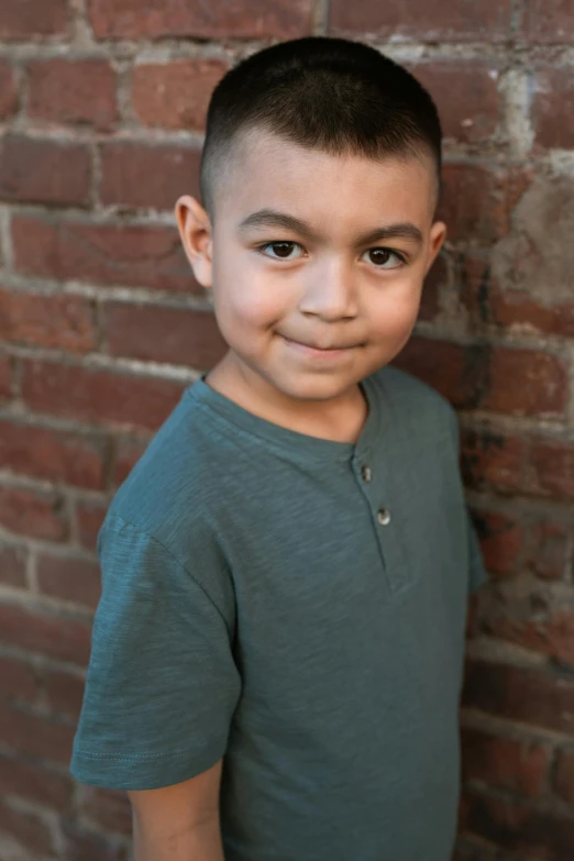 a young boy standing in front of a brick wall, headshot and bodyshot, medium skin tone, promo image, full - color