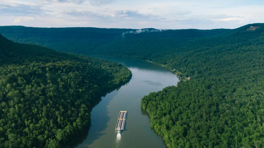 a large boat traveling down a river next to a forest, by Dan Frazier, pexels contest winner, hudson river school, in louisiana, drone footage, looking over west virginia, with an intricate