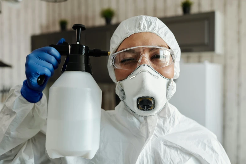 a woman in a protective suit holding a spray bottle, a portrait, by Julia Pishtar, shutterstock, fan favorite, sharing an oxygen tank, professional closeup photo, clean room