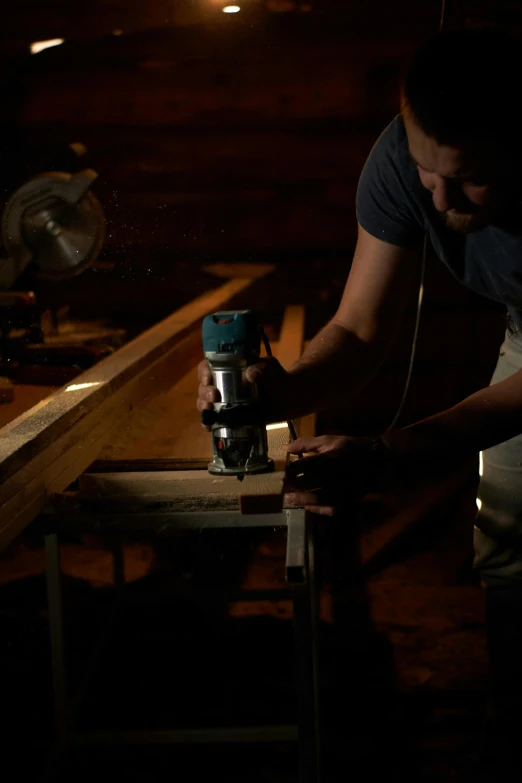 a man is working on a piece of wood, pexels contest winner, mid night, production still, profile image, lachlan bailey