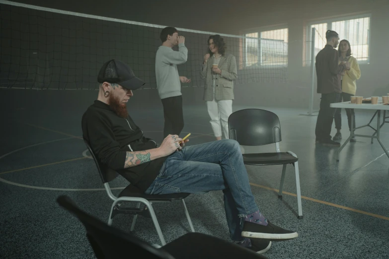 a man sitting on a chair in a room, a tattoo, pexels contest winner, hyperrealism, volley court background, unreal engine. film still, group of people in a dark room, calmly conversing 8k