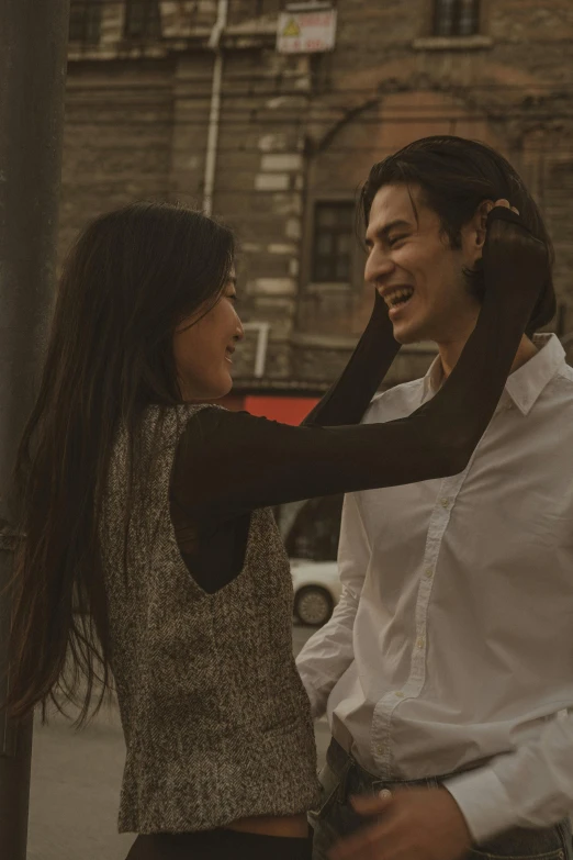 a man standing next to a woman on a city street, pexels contest winner, renaissance, cai xukun, smiling and dancing, with his long black hair, indie film