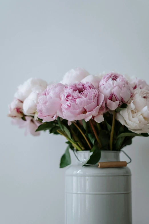 a white vase filled with pink flowers on top of a table, unsplash, peony, aged, full product shot, large tall