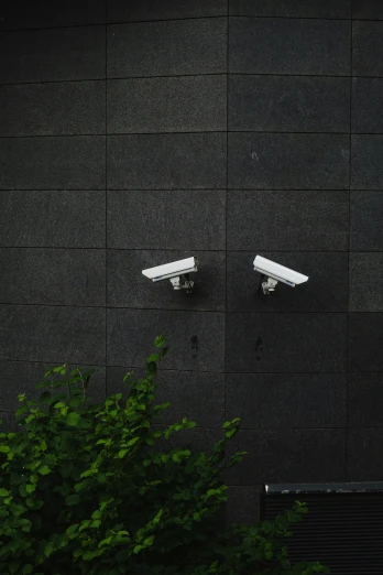 three cameras mounted to the side of a building, by Carey Morris, unsplash, hedge, crimes, 15081959 21121991 01012000 4k, lighting on concrete