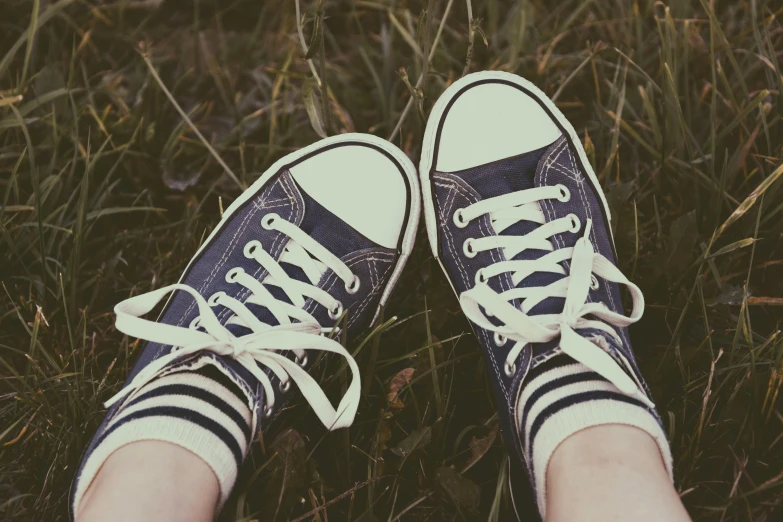 a pair of shoes sitting on top of a lush green field, pexels contest winner, realism, teenage, retro colour, converse, striped socks
