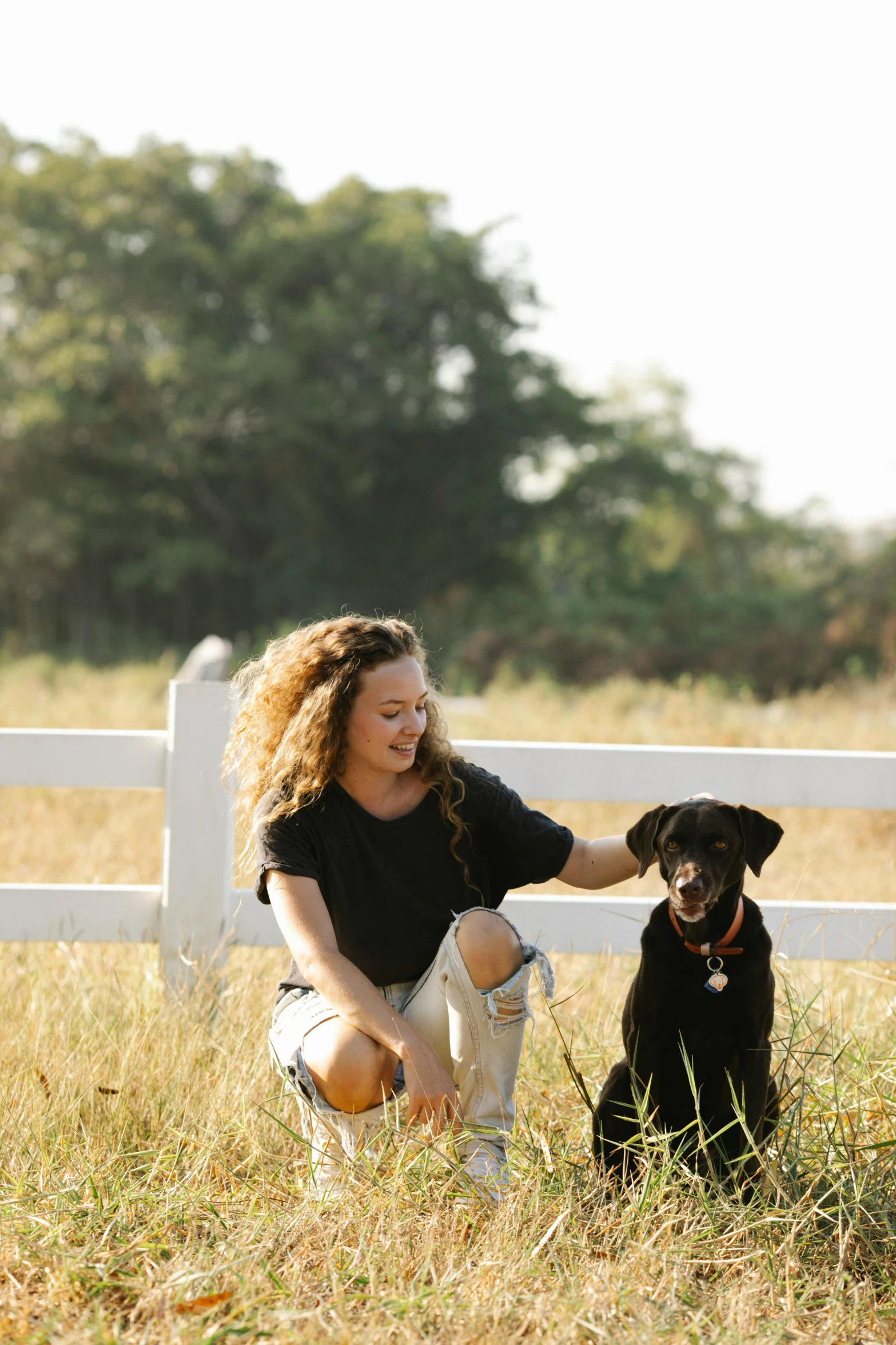 a woman kneeling next to a black dog in a field, profile image, avatar image, outdoor photo, large)}]