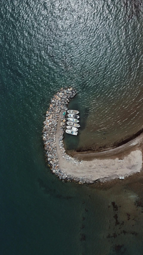 an aerial view of a body of water, by Jesper Knudsen, pexels contest winner, land art, some boats, grey, near a jetty, greece