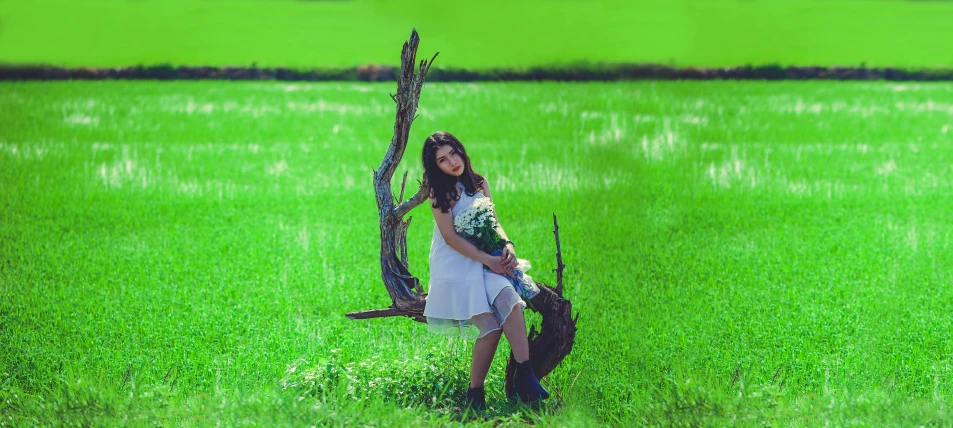 a woman sitting on a tree branch in a field, a picture, in style of lam manh, portrait image, #green, trending photo