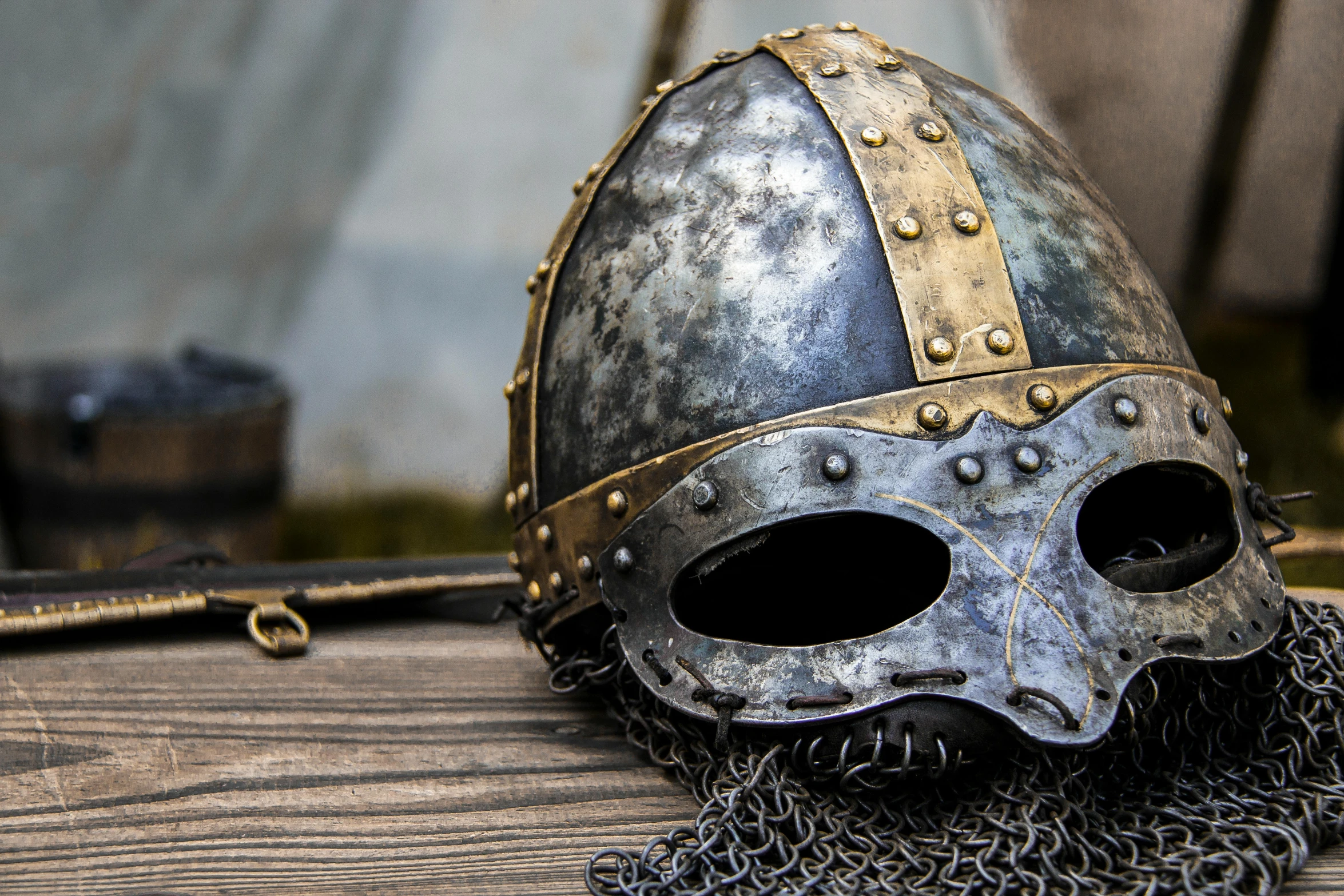 a helmet sitting on top of a wooden table, inspired by Þórarinn B. Þorláksson, unsplash, renaissance, metal mask, sqare-jawed in medieval clothing, trending photo, celtic culture
