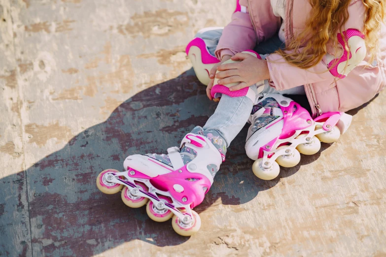 a little girl sitting on top of a skateboard, by Julia Pishtar, shutterstock, streamlined pink armor, rollerblades, high angle close up shot, 000 — википедия