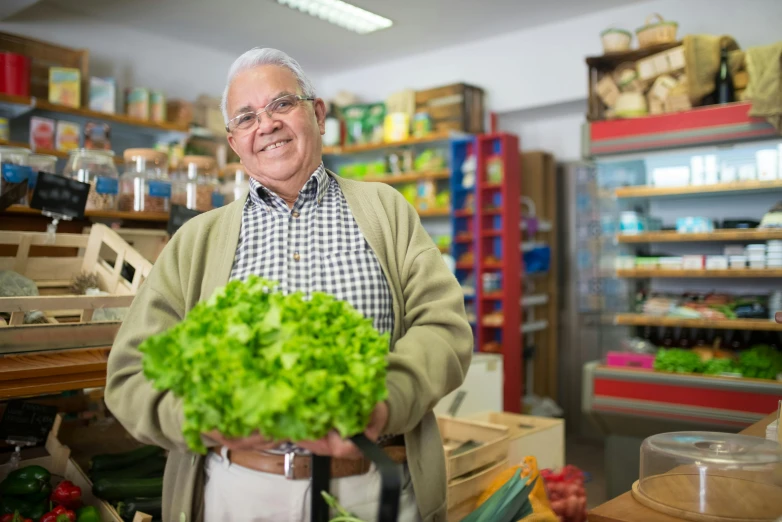 a man holding a bunch of lettuce in a store, a portrait, pexels contest winner, older male, avatar image, exiting store, greens)