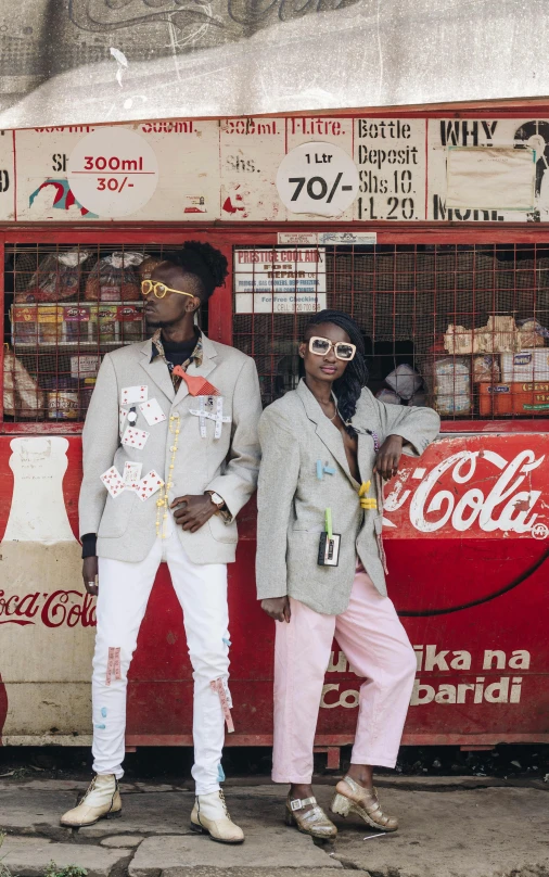 a group of people standing in front of a vending machine, an album cover, by Ingrida Kadaka, pexels, afrofuturism, coka-cola advertisement, dressed in a worn, high fashion themed, 15081959 21121991 01012000 4k