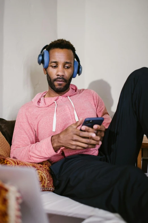 a man sitting on a couch with headphones on, by Everett Warner, trending on pexels, renaissance, blue turtleneck, a colorful, who is a male android, low fi