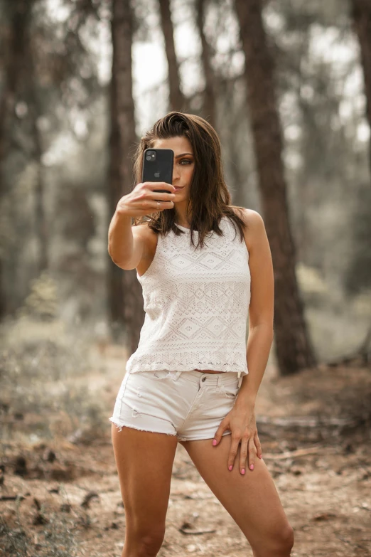 a woman taking a picture of herself in the woods, a picture, pexels contest winner, aestheticism, white tank top, australian, short shorts, #oc