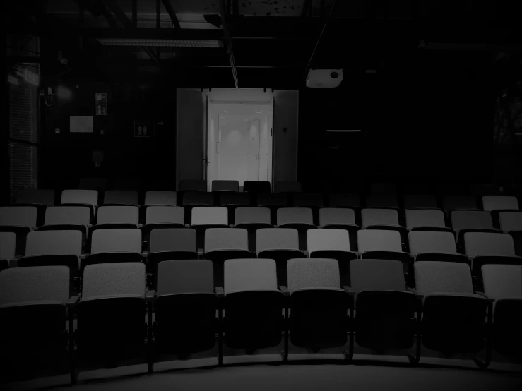 a black and white photo of an empty auditorium, pexels, conceptual art, background image, pitch black background, actors, back room