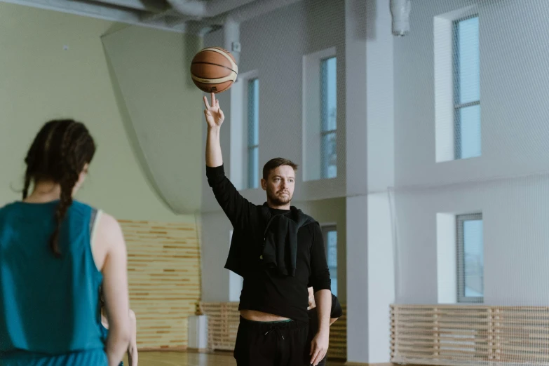 a man standing on top of a basketball court holding a basketball, by Gavin Hamilton, pexels contest winner, emma watson as a tall nba player, mana shooting from his hands, anastasia ovchinnikova, in a gym