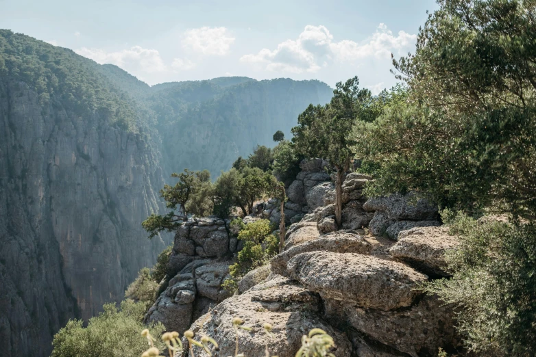 a group of people standing on top of a mountain, by Emma Andijewska, pexels contest winner, les nabis, detailed trees and cliffs, mediterranean, avatar image, new mexico