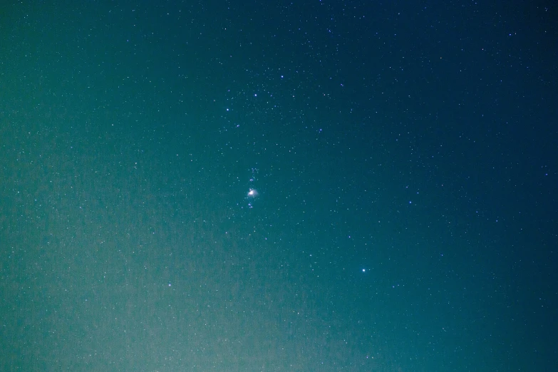 a man riding a snowboard on top of a snow covered slope, an album cover, pexels, minimalism, night covered in stars, teal color graded, unknown zodiac sign, comet