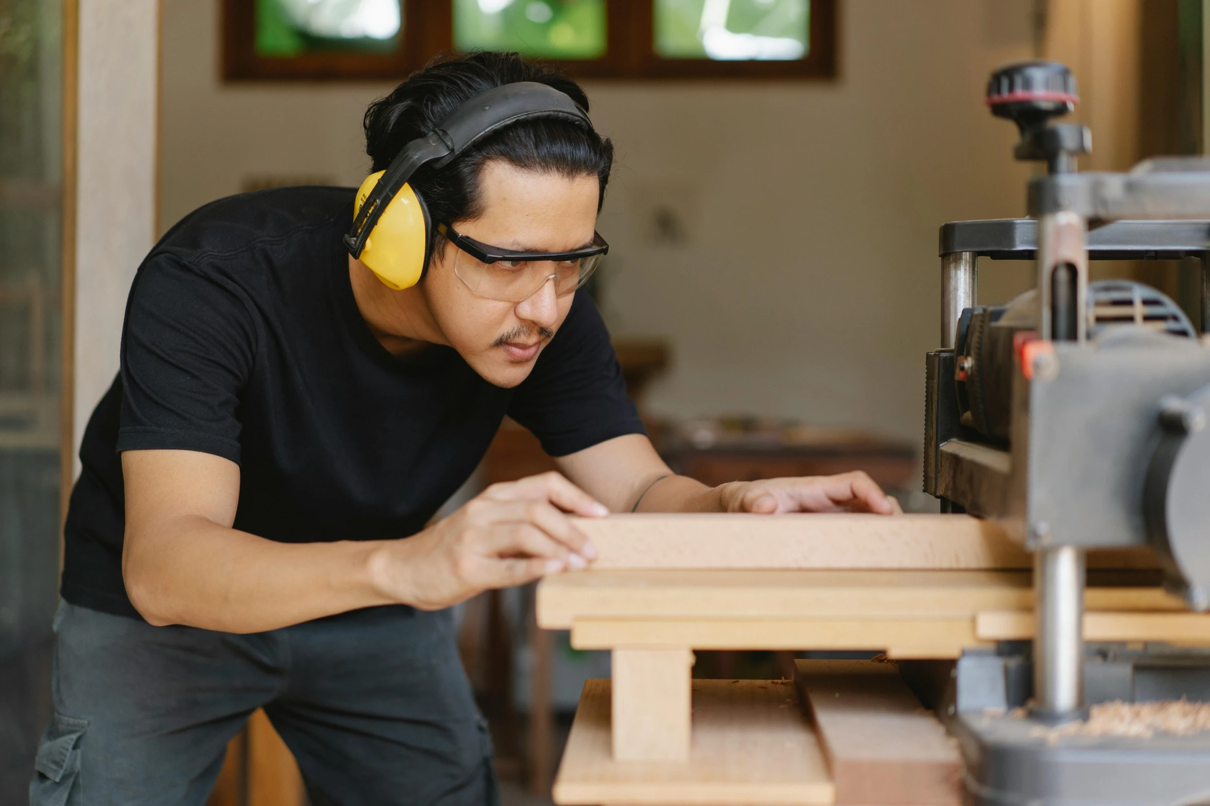 a man wearing headphones working on a piece of wood, trending on pexels, avatar image, australian, asian male, thumbnail