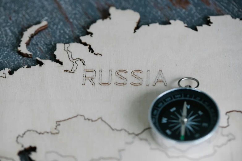 a compass sitting on top of a map, trending on unsplash, socialist realism, photo of putin, carved in wood, an escape room in a small, 15081959 21121991 01012000 4k