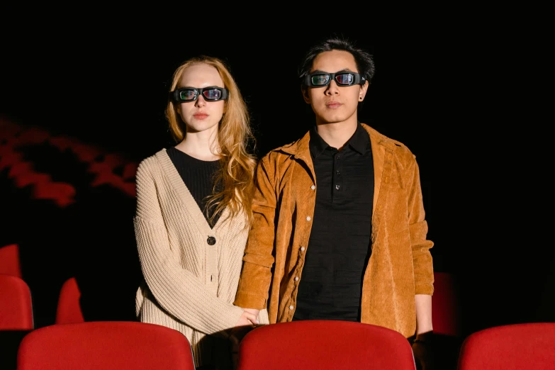 a man and woman standing next to each other in a movie theater, a hologram, pexels, hyperrealism, wearing 3 d glasses, ruan jia and fenghua zhong, [ theatrical ], petra collins and mc. escher