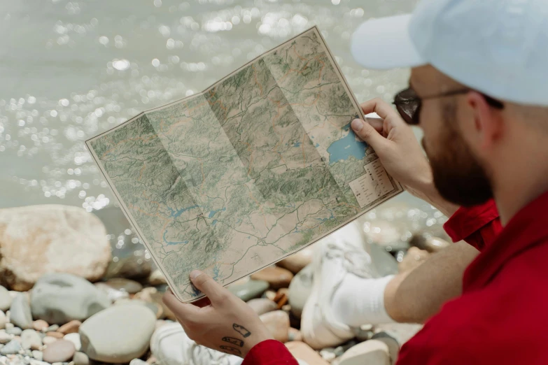 a man is looking at a map by the water, by Jessie Algie, pexels contest winner, wheres wally, high quality screenshot, how river, rectangle