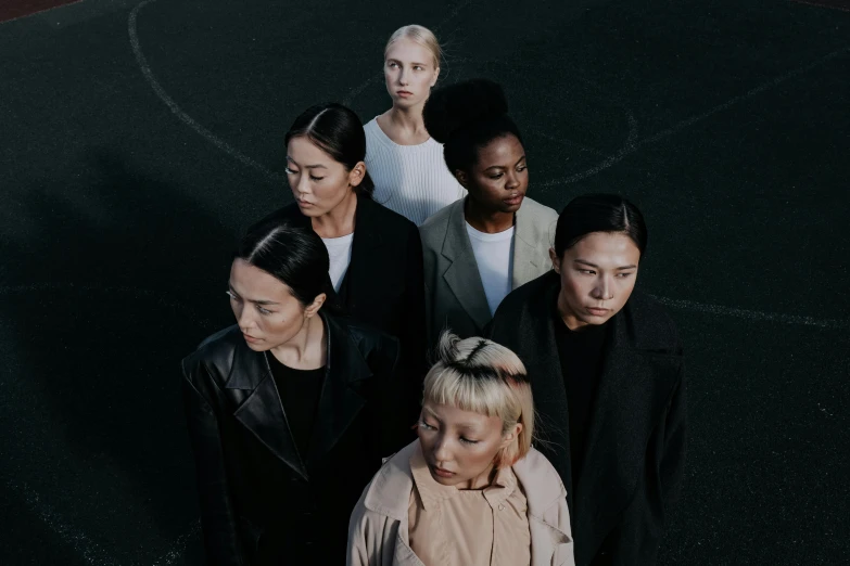 a group of people standing on top of a basketball court, an album cover, by Emma Andijewska, pexels contest winner, women's faces, ethnicity : japanese, a full portrait of nordic female, tones of black