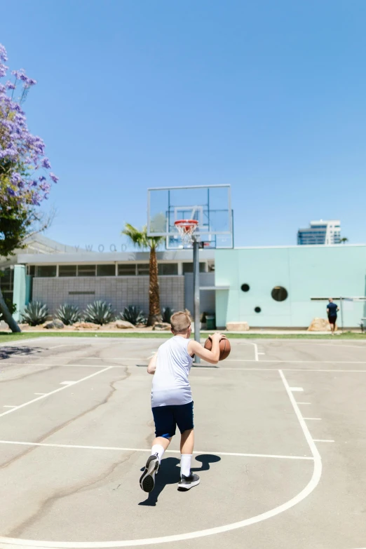 a man standing on top of a basketball court holding a basketball, dribble, heidelberg school, with palm trees in the back, kids place, jen atkin, mid action swing