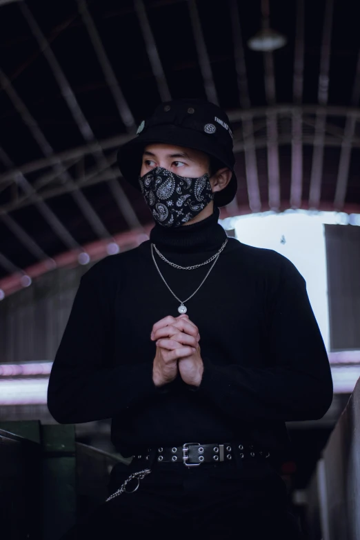 a man in a black shirt and a black mask, inspired by Zhu Da, trending on pexels, wearing a chocker and cute hat, standing in an arena, paisley, avatar image