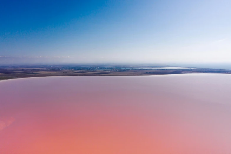 an aerial view of a large body of water, by Peter Churcher, trending on unsplash, color field, the sky is pink, “ iron bark, flying over the horizon, red lake