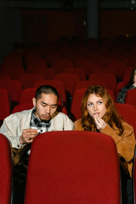 a group of people sitting in a movie theater, inspired by Nan Goldin, trending on pexels, renaissance, plain background, couple, asian man, [ theatrical ]