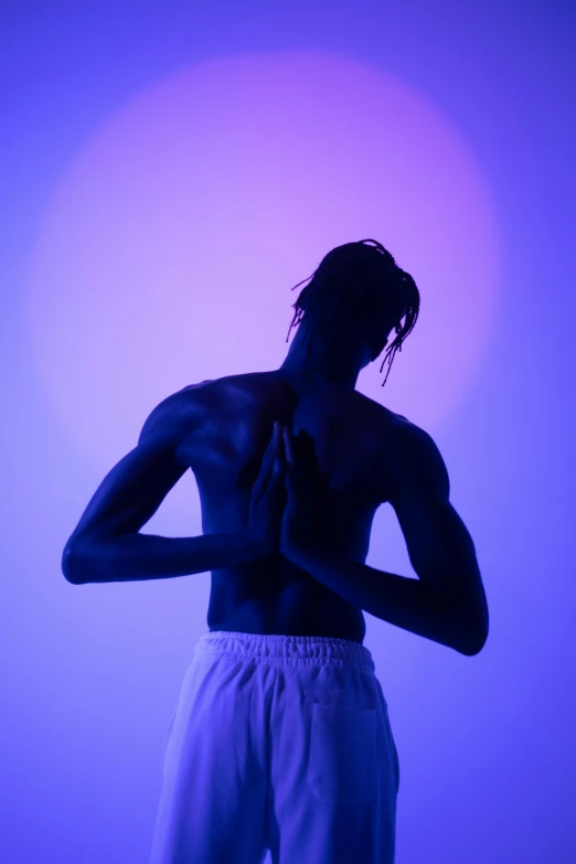 a man standing in front of a purple light, showing her shoulder from back, meditative sacral pose, young thug, dark blue skin