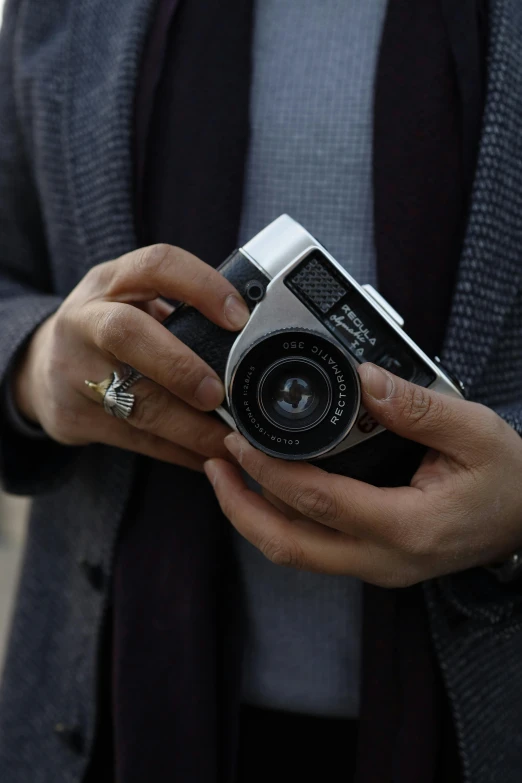 a close up of a person holding a camera, inspired by Vivian Maier, unsplash, photorealism, medium format color photography, 1 9 7 0 s analog aesthetic, fujifilm x - pro 2, highly polished