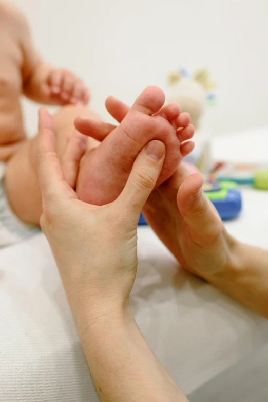 a close up of a person holding a baby's foot, diagnostics, softplay, thumbnail, center