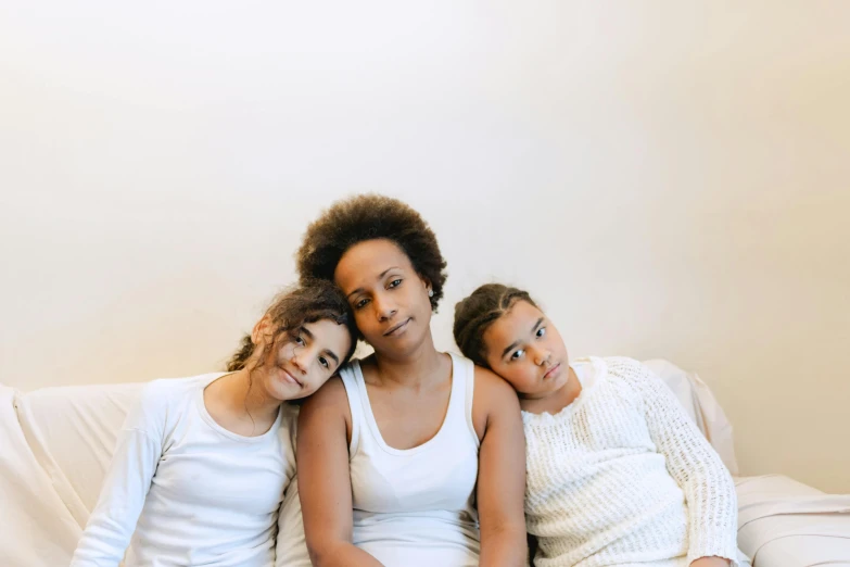 three women sitting on a couch next to each other, by Matija Jama, pexels, husband wife and son, black teenage girl, wearing white clothes, avatar image