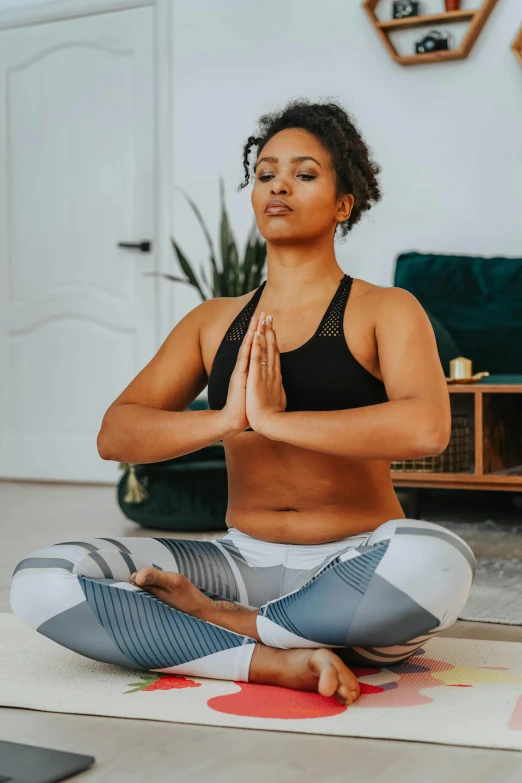 a woman sitting on a yoga mat in a living room, photo of a black woman, meditating in lotus position, promo image, sports photo