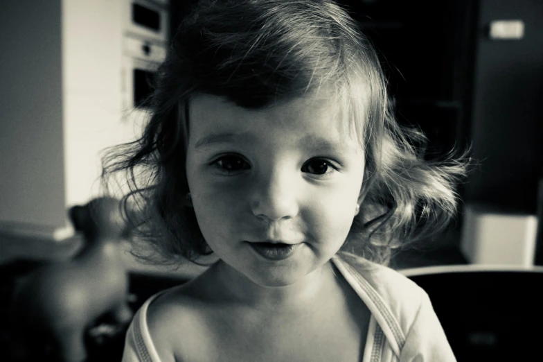 a black and white photo of a little girl, a black and white photo, pexels contest winner, short brown hair and large eyes, 2 years old, bedhead, retro stylised