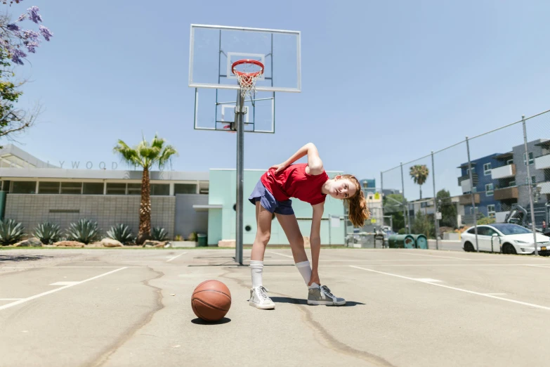 a woman standing on top of a basketball court next to a basketball, dribble, sadie sink, wearing red converse shoes, 15081959 21121991 01012000 4k, environmental shot