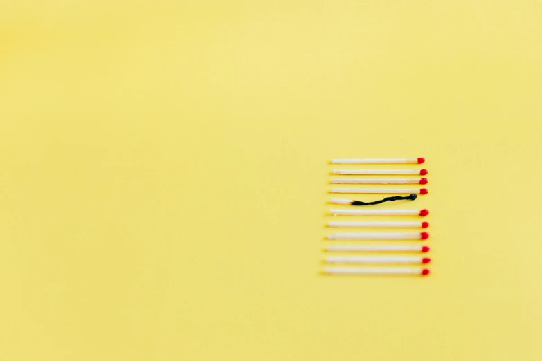 a group of matches sitting on top of a yellow surface