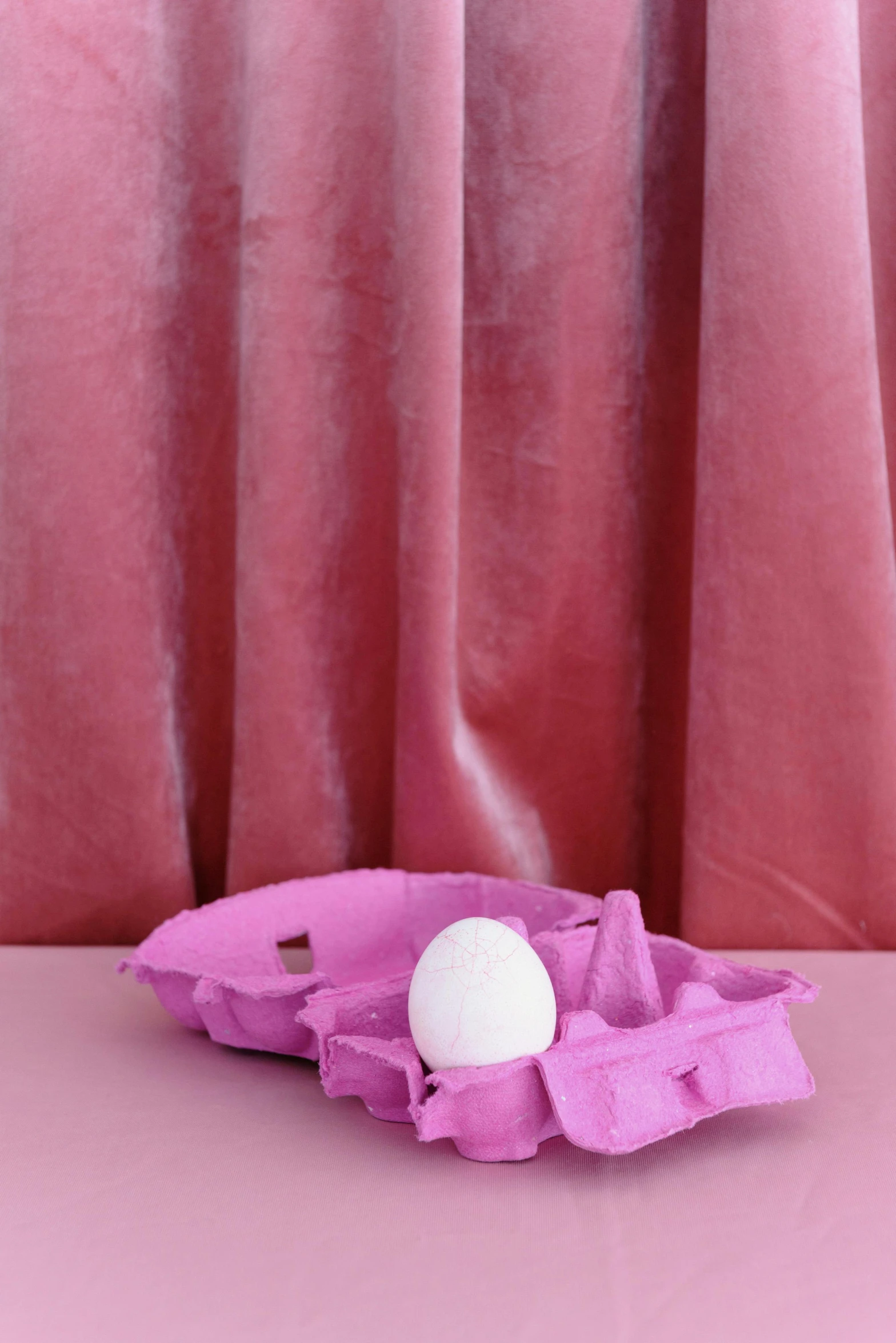 an egg in an egg carton on a table, by Nathalie Rattner, trending on instagram, brightly lit pink room, purple drapery, tissue ornament, velvet