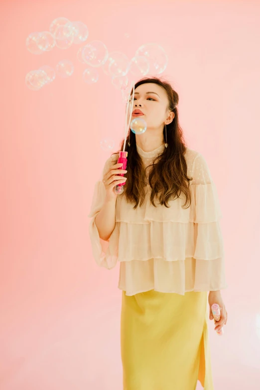 a woman blowing bubbles on a pink background, an album cover, by Ayami Kojima, trending on pexels, wavy hair yellow theme, outfit photograph, profile image, moviestill