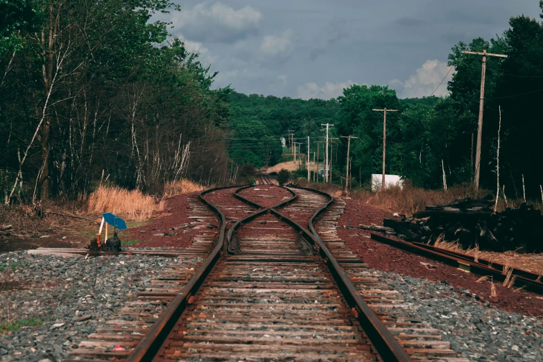 a person with an umbrella standing on a train track, pexels contest winner, a screenshot of a rusty, very detailed curve, chemrail, crossing the line