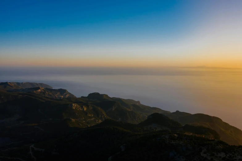 a view of the ocean from the top of a mountain, by Tobias Stimmer, unsplash contest winner, romanticism, marbella, blue sky at sunset, monserrat gudiol, unsplash 4k