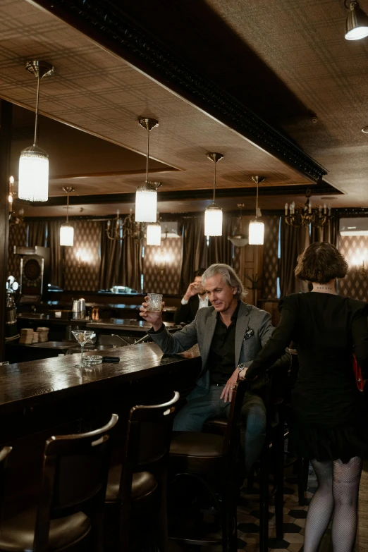 a group of people sitting at a bar, robert plant, luxurious environment, shot with sony alpha, david spade