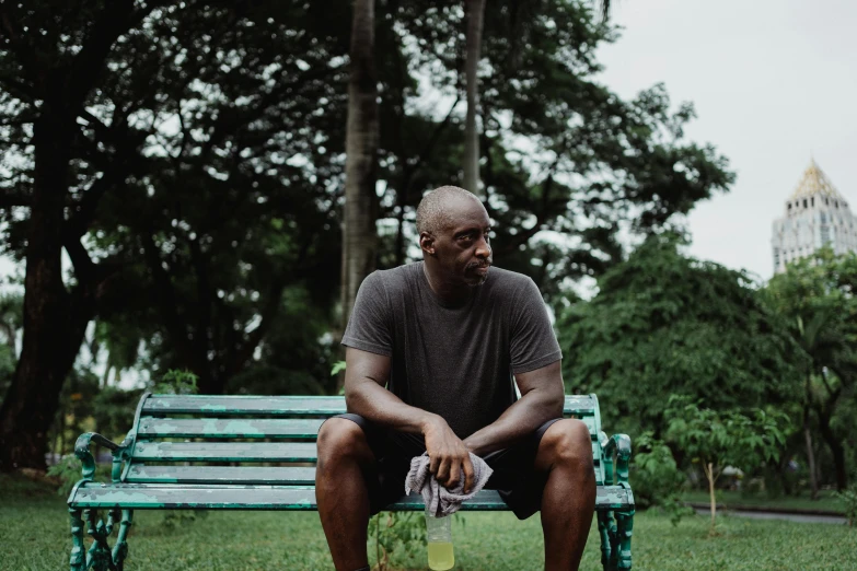 a man sitting on a bench in a park, kevin garnett, hydration, profile image, portrait image