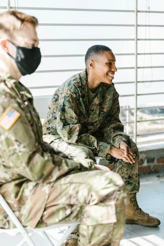 a couple of military men sitting next to each other, pexels, both laughing, diverse, instagram post, woman