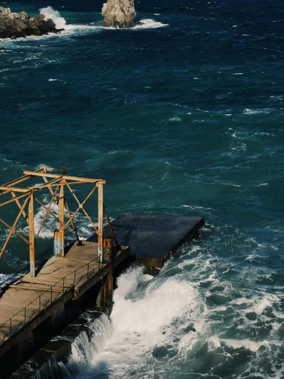 a man standing on top of a wooden pier next to the ocean, an album cover, by Elsa Bleda, turbulent water, a high angle shot, closeup of magic water gate, looking to the right